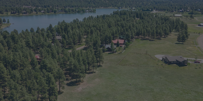 Scenic view of Lake Pagosa with surrounding pine trees, custom homes, and the snow-capped Continental Divide in Pagosa Springs, Colorado.